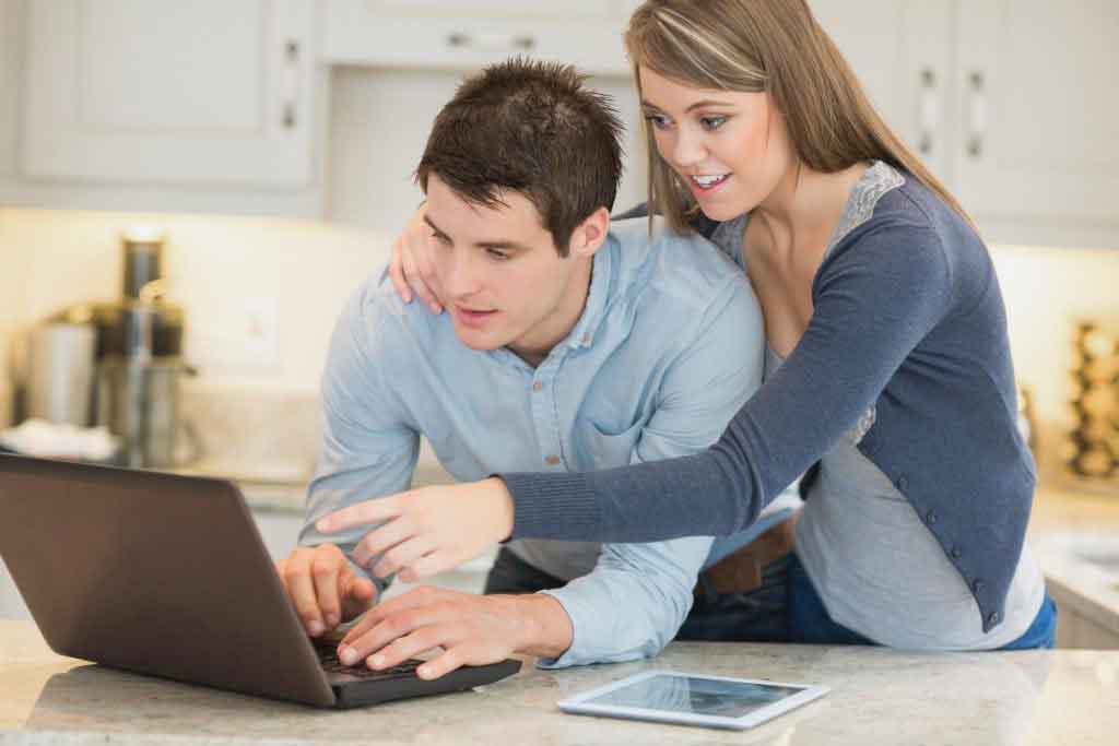 couple researching marketing costs for selling home