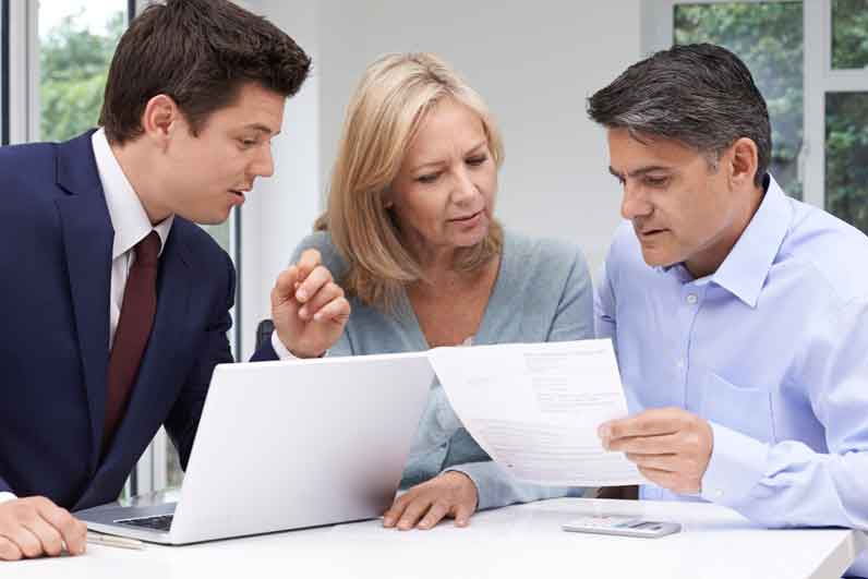 Mature Couple Meeting With Financial Advisor At Home