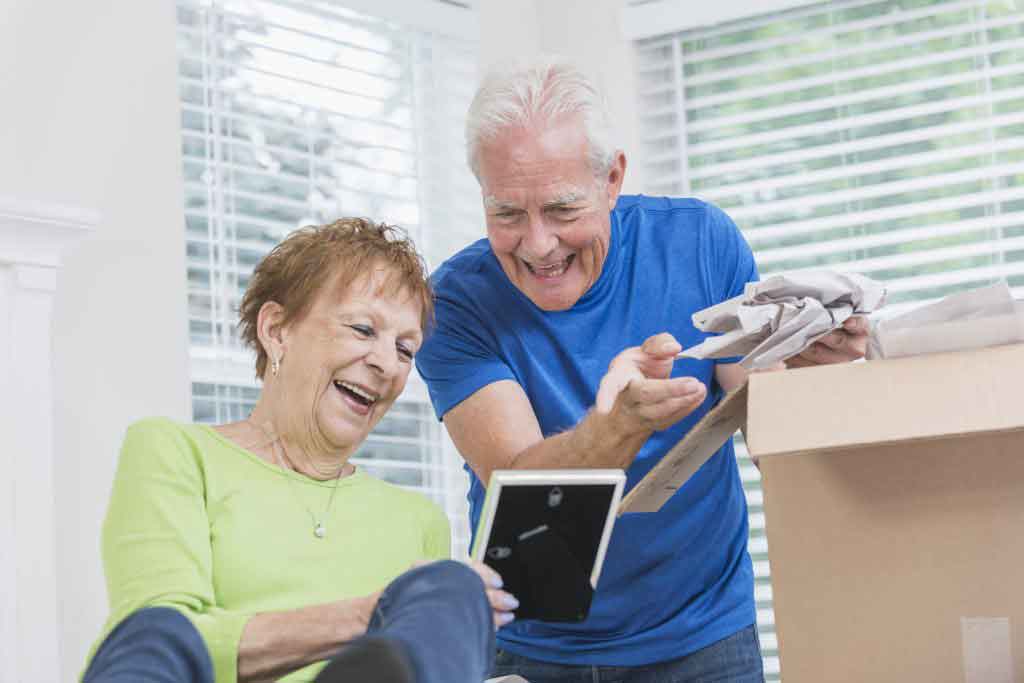 Senior couple packing box, looking at picture frame